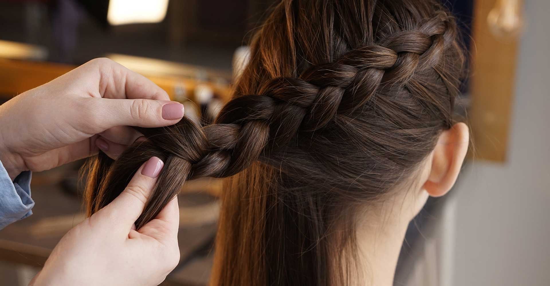 Profissional fazendo tranca em cabelo castanho escuro
